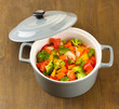 Vegetable stew in gray pot on wooden background