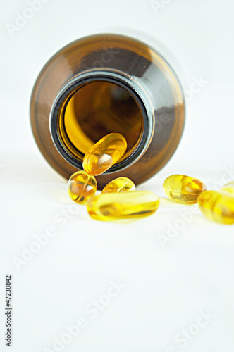 Photo: Fish oil capsules spilled from bottle Fish oil capsules spilled from bottle