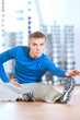 Man doing stretching exercises at the gym