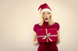 beautiful blonde woman holding a christmas gift is smiling