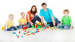 Photo: Happy family. Parents with three kids playing blocks over white Happy family. Parents with three kids playing blocks over white