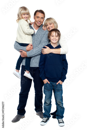 Photo: Affectionate family of four posing in winter outfits Affectionate family of four posing in winter outfits