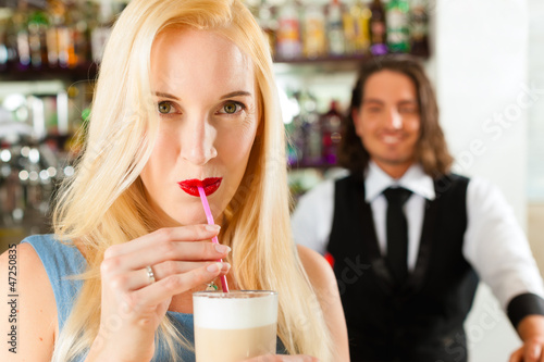 Photo: Barista with client in his cafe or coffeeshop Barista with client in his cafe or coffeeshop