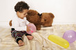 Kleinkind mit Teddybär und Luftballons