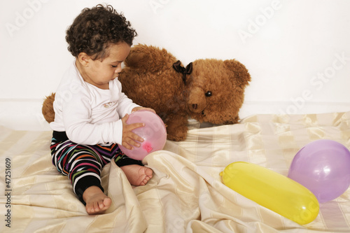 Photo: Kleinkind mit Teddybär und Luftballons Kleinkind mit Teddybär und Luftballons