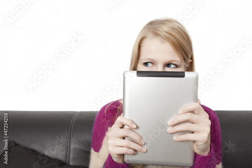 Photo: Seitenblick einer Frau die ein Tablet PC vor ihr Gesicht hält Seitenblick einer Frau die ein Tablet PC vor ihr Gesicht hält