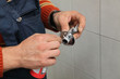 Plumber putting teflon wire for thread sealing to tap