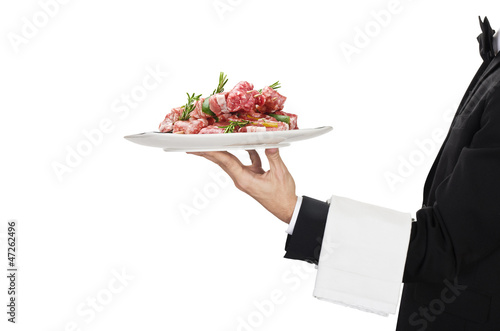 Photo: young waiter in work uniformon with sausage young waiter in work uniformon with sausage