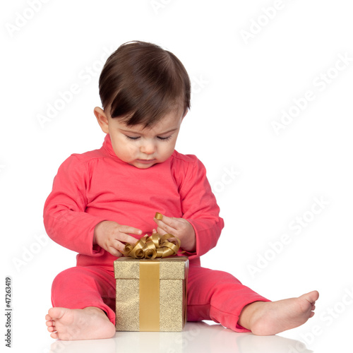 Photo: Adorable baby playing with a present Adorable baby playing with a present