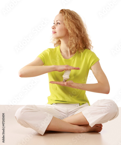 Photo: Young woman with an energy-saving bulb Young woman with an energy-saving bulb