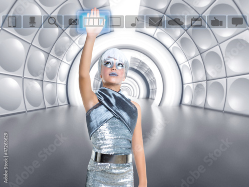 Photo: futuristic kid girl in silver touching finger icons futuristic kid girl in silver touching finger icons