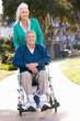 Senior Woman Pushing Husband In Wheelchair