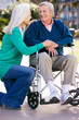 Senior Woman Pushing Husband In Wheelchair