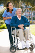 Photo: Carer Pushing Senior Man In Wheelchair Carer Pushing Senior Man In Wheelchair