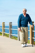 Senior Man Walking Along Path By The Sea