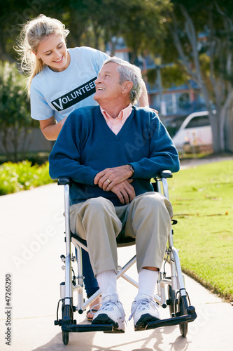 Photo: Teenage Volunteer Pushing Senior Man In Wheelchair Teenage Volunteer Pushing Senior Man In Wheelchair