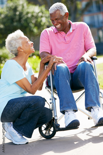 Photo: Senior Woman Pushing Husband In Wheelchair Senior Woman Pushing Husband In Wheelchair