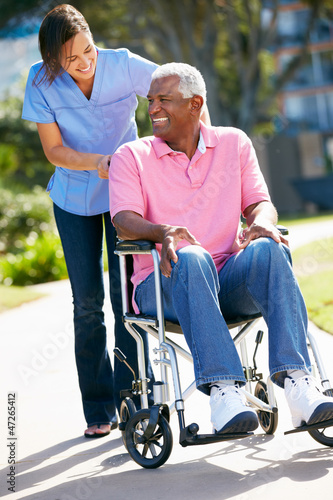 Photo: Carer Pushing Senior Man In Wheelchair Carer Pushing Senior Man In Wheelchair