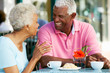 Senior Couple Enjoying Snack At Outdoor Café