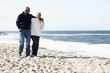 Senior Couple Walking Along Beach Together