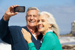 Senior Couple With Camera On Beach