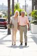 Senior Couple Walking Along Street Together