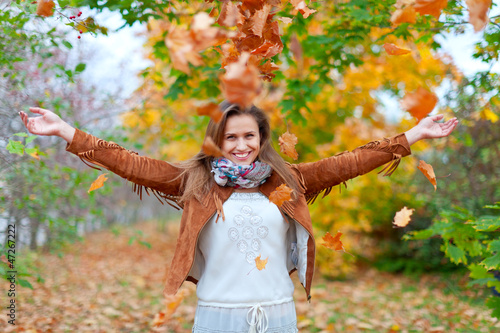 Photo: Happy girl throws maple leaves Happy girl throws maple leaves