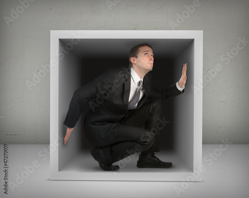 Photo: Businessman in a box,gray background Businessman in a box,gray background