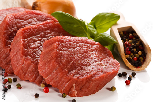 Photo: Raw beef and vegetables on white background Raw beef and vegetables on white background