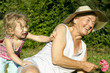 Photo: Grandma and granddaughter play in garden Grandma and granddaughter play in garden