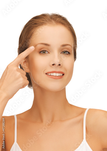 Photo: beautiful woman pointing to eyebrow beautiful woman pointing to eyebrow