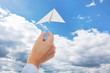 Hand throwing paper airplanes in the air