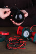 Human makes timebomb on wooden table on black background