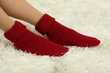 Female legs in colorful socks on  white carpet background