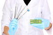 dentists hands in blue medical gloves with dental tools and