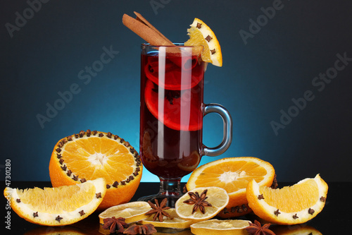 Photo: Fragrant mulled wine in glass with spices and oranges around Fragrant mulled wine in glass with spices and oranges around
