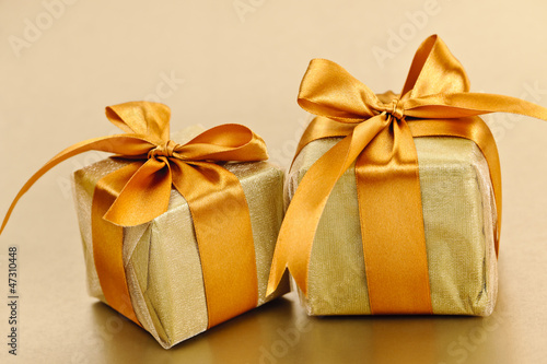 Photo: Two golden wrapped gift boxes Two golden wrapped gift boxes