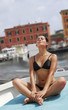Foto: Joven mujer relajada tomando sol en una barca,yoga. Joven mujer relajada tomando sol en una barca,yoga.