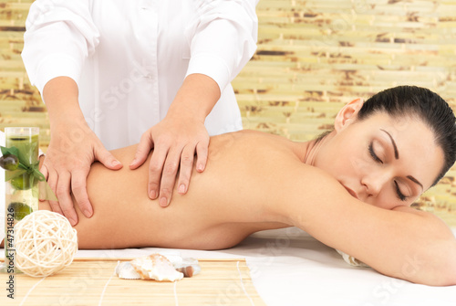 Photo: Woman on therapy massage of back in spa salon Woman on therapy massage of back in spa salon