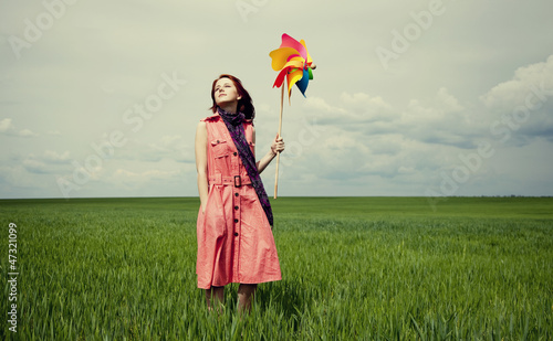 Photo: Young women with toy wind turbine at green wheat field. Young women with toy wind turbine at green wheat field.