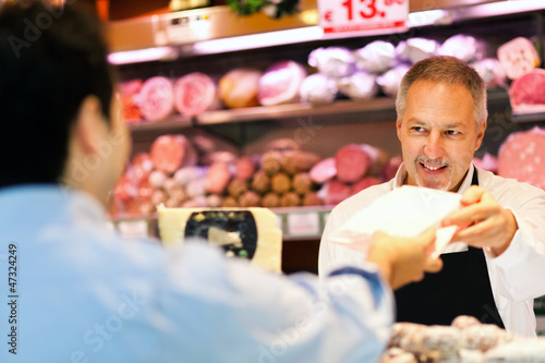 Photo: Shopkeeper serving a costumer Shopkeeper serving a costumer