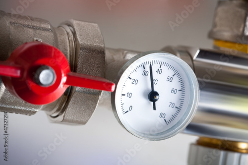 Photo: Water meters with red valve and metal pipes Water meters with red valve and metal pipes
