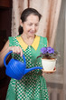 woman caring for potted flower