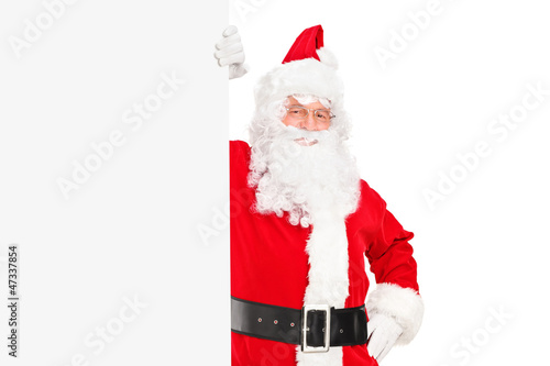 Photo: A smiling Santa Claus posing next to a billboard A smiling Santa Claus posing next to a billboard