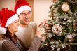 Happy Couple Decorating Christmas Tree in their Home