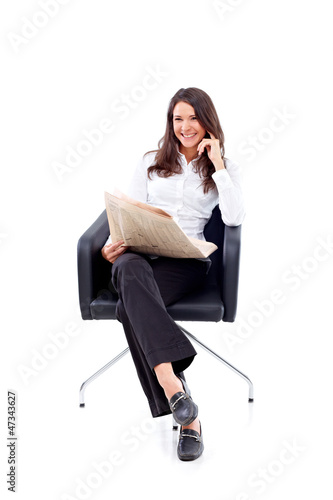 Photo: Casual 20s woman reading stock rates in newspaper 4 Casual 20s woman reading stock rates in newspaper 4