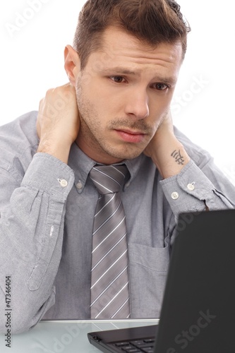 Photo: Tired businessman working on laptop Tired businessman working on laptop