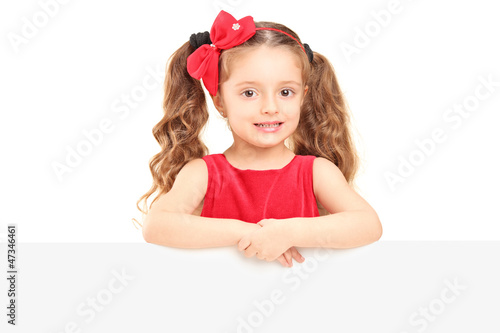 Photo: A small girl posing behind a panel A small girl posing behind a panel