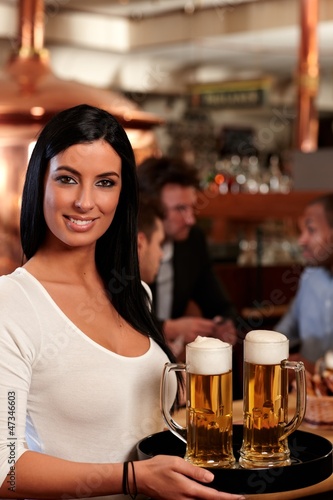 Photo: Beautiful waitress serving beer Beautiful waitress serving beer