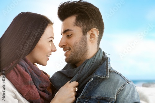 Photo: Loving couple kissing on the beach at autumn Loving couple kissing on the beach at autumn